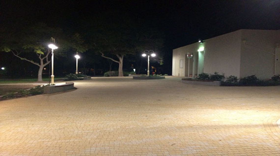 הרחבה בלילה. מוארת על-ידי פנסי רחוב בצבע קרם.