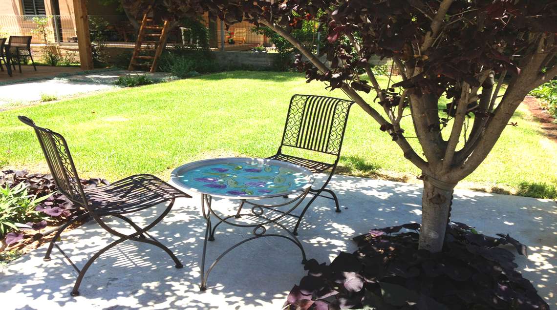 שולחן קטן ושני כסאות תחת שזיף פיסרדי