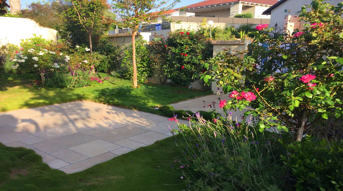 שביל כניסה לבית. עשוי פלטות אבן משולבות בתוך דשא גבעות.