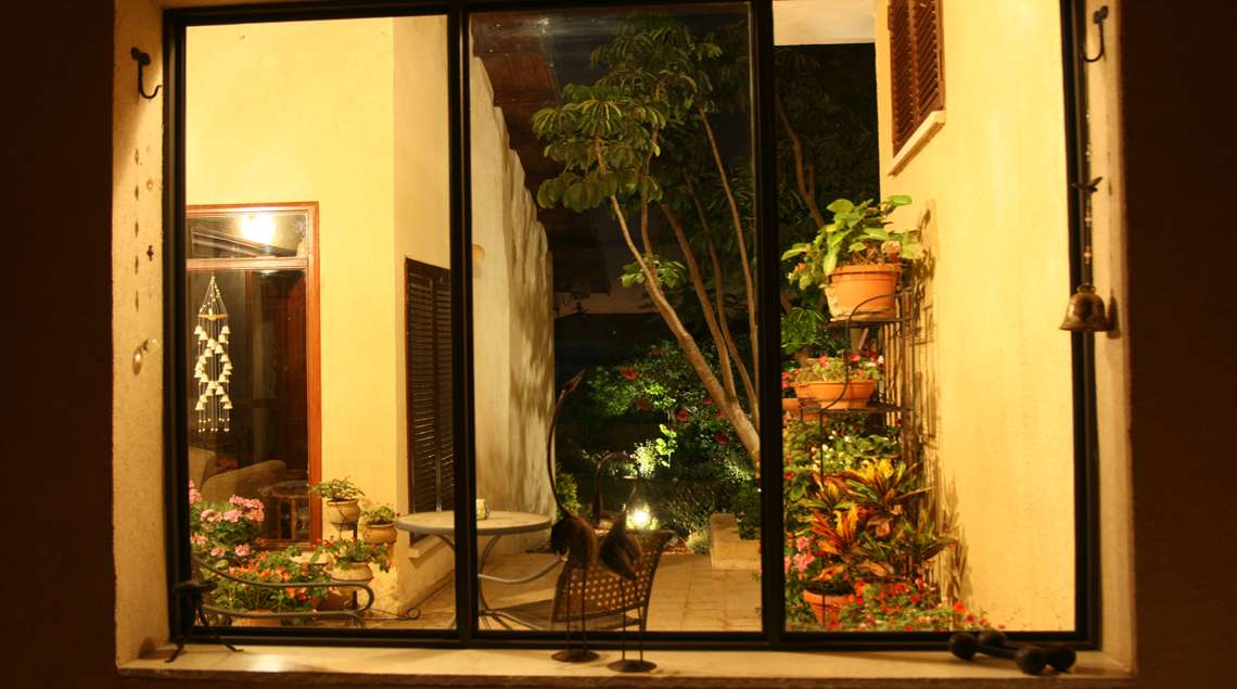 פאטיו קטן מואר בתאורת גינה בלילה.