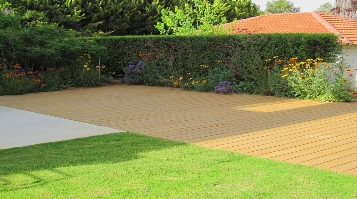 דק, בטון מוחלק ומדשאה ושיחים סביב.