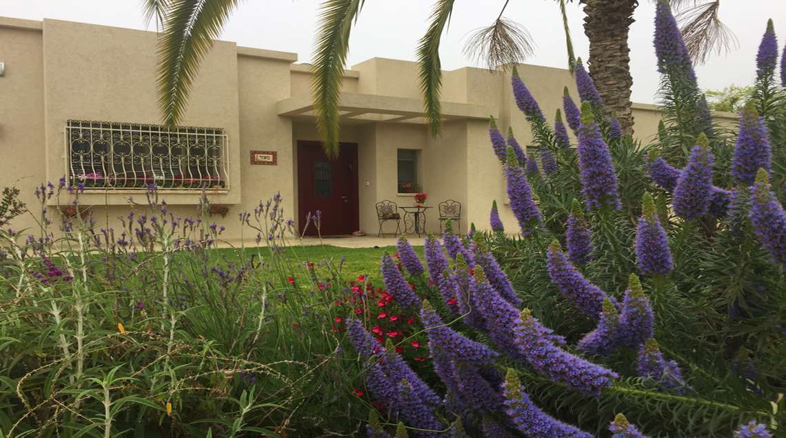 שולחן עגול מפסיפס ושני כיסאות במבואה של הבית